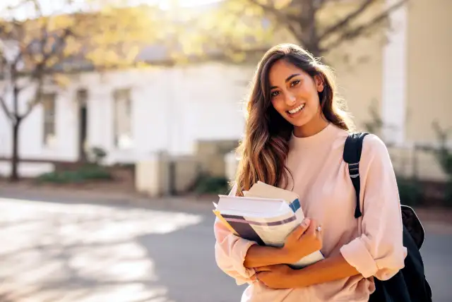 estudante universitária com livros nas mãos